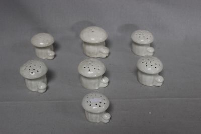 a lot of small white ceramic mushrooms on the table