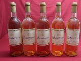 six bottles of wine are lined up in a row on a pink background
