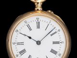 une montre de poche en or avec des chiffres romains sur le cadran