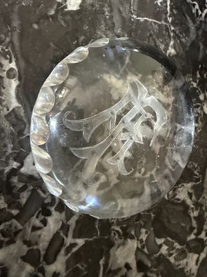 une plaque de verre portant un monogramme, posée sur une table