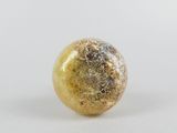 a close up of a yellow and black marble ball on a white surface