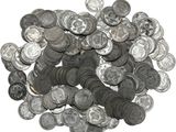a pile of old silver coins on a white surface