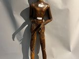 statue en bois représentant un homme tenant un couteau dans chaque main