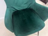 une chaise verte qui se trouve dans un coin de la pièce