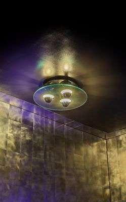 une photo d'une salle de bains avec une pomme de douche et des lumières