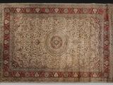 un tapis ancien avec une bordure rouge et un motif en médaillon