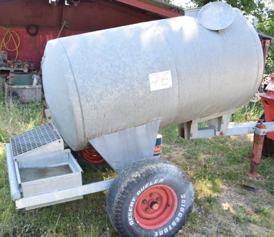 a large metal tank sitting on a trailer in the grass