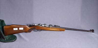 the rifle is laying on the table next to the hat