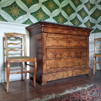deux chaises et une commode dans une pièce avec du papier peint
