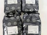quatre sacs de nourriture noire posés sur une table blanche