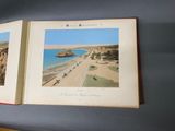 two open books with pictures of a beach and a boat in the water