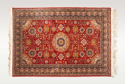 un tapis rouge orné d'un motif en médaillon et de franges