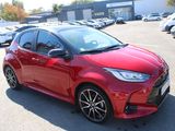 the red toyota yaris is parked in a parking lot