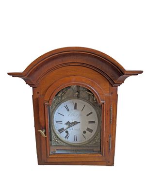 a wooden clock with roman numerals on the face