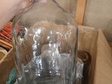 a person holding a large glass bottle in a box