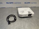 a white projector sitting on top of a table next to a cord