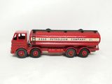 un camion jouet rouge posé sur une surface blanche