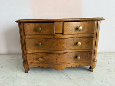 une photo d'une commode en bois avec des poignées en laiton