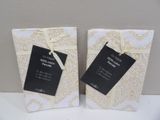 une paire de sacs-cadeaux blancs et dorés, ornés d'étiquettes noires
