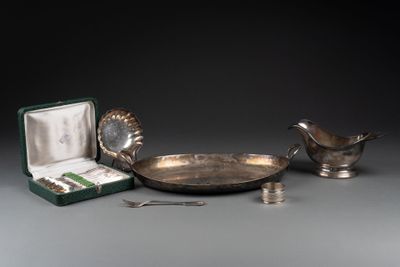 une assiette en argent avec une cuillère et un repose-cuillère posés sur une table