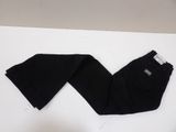 black skinny jeans laying on top of a white table next to a pair of shoes