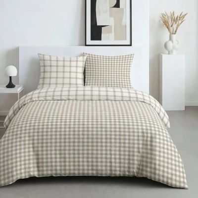un lit blanc avec une couette à carreaux et des oreillers dans une chambre