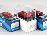 trois modèles réduits de voitures dans une vitrine posée sur un support blanc