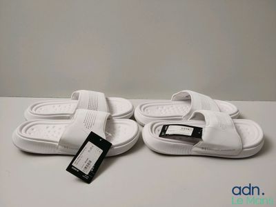 Sandales blanches adidas de type « slides » avec une étiquette sur le côté