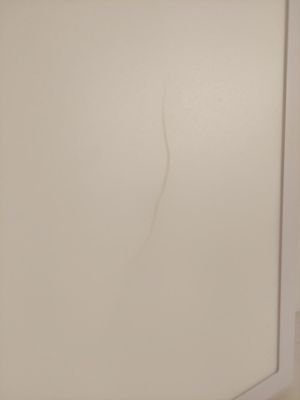 une fissure dans le mur d'une salle de bains équipée de toilettes