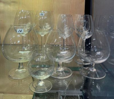de nombreux verres à vin posés sur une étagère en verre