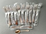 a lot of forks and spoons wrapped in plastic bags