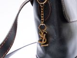a black purse with a gold y charm hanging from it
