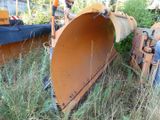 a large orange plow sitting in the middle of a field