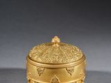 a gold plated box with a decorative design on the lid
