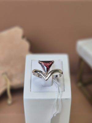 a ring with a red stone in a white box