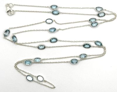 Gros plan sur un collier orné de pierres bleues sur fond blanc