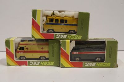 trois boîtes contenant des ambulances miniatures, posées sur une surface blanche