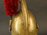 a gold helmet with a red pom pom on top of it