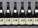 six bottles of wine are lined up in a row on a table