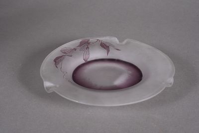 a glass ashtray with a flower design on it