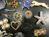 a lot of brooches that are on a table