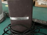 a brown speaker sitting on top of a table next to a remote
