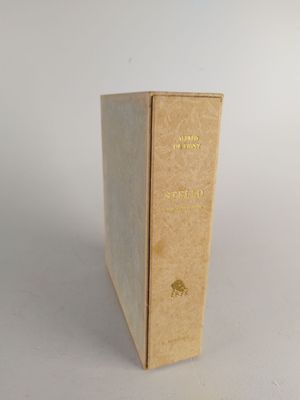 an old book sitting on top of a white table next to a white wall