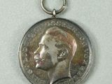 an image of a silver medal with a man ' s face on it