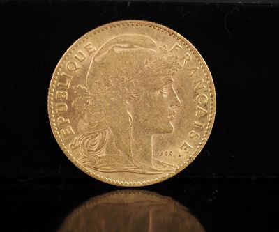 gros plan d'une pièce d'or sur une surface noire