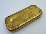 une barre d'or posée sur une surface blanche