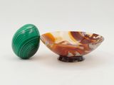 un bol en marbre et un œuf en marbre posés sur une surface blanche