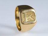 un gros plan d'une bague en or sur laquelle figure la lettre « k »