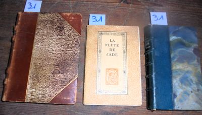 Plusieurs livres sont alignés sur une table en bois, accompagnés de numéros.