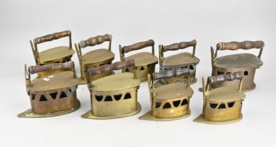 six lampes à huile en laiton ancien sont alignées sur une surface blanche